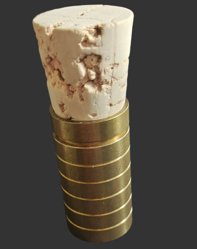 Cork stopper with gold metal sleeve on a black background