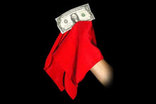 Red handkerchief with a dollar bill held by a hand against a black background