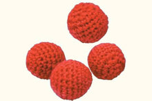 Four red crochet balls on a white background