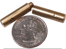 Two small brass cylindrical objects next to a quarter on a white background with text 'Quarter Not Included'.