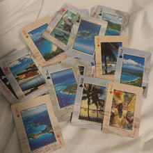 Set of playing cards with scenic images on a white surface
