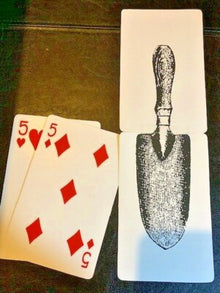 Two playing cards with a five of hearts and a five of diamonds, and a trowel illustration on a separate card.