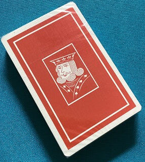 Red playing card with a central design on a blue background