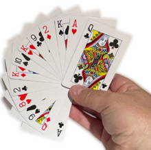 Hand holding a deck of playing cards with King, Queen, and Jack cards displayed.