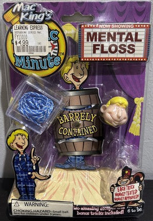 Toy figure in packaging with 'Mental Floss' and 'Barley Contained' text on a gray background