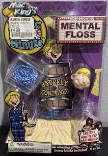 Toy figure in packaging with 'Mental Floss' and 'Barley Contained' text on a gray background