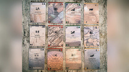 Set of playing cards with unique designs on a wooden surface