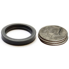 Rubber gasket next to a stack of coins on a white background