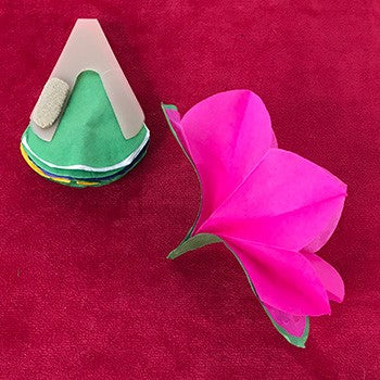 Green and pink felt flower on a red background