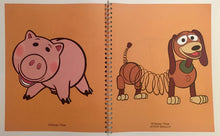 Spiral-bound notebook with cartoon illustrations of a pig and a dog on an orange background