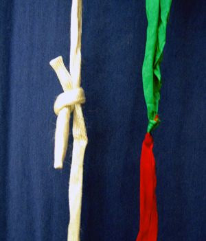 Close-up of a white rope with a knot against a dark blue background