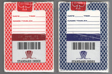 Two playing card packs with labels and barcodes on a gray background
