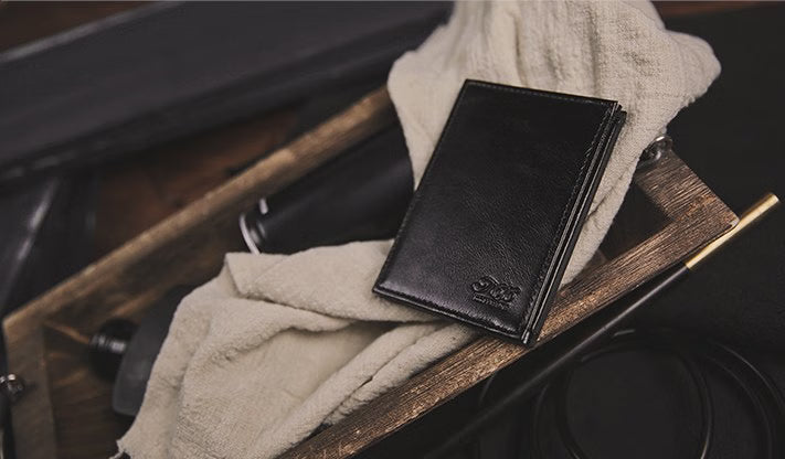 Black leather wallet on a wooden surface with a blurred background
